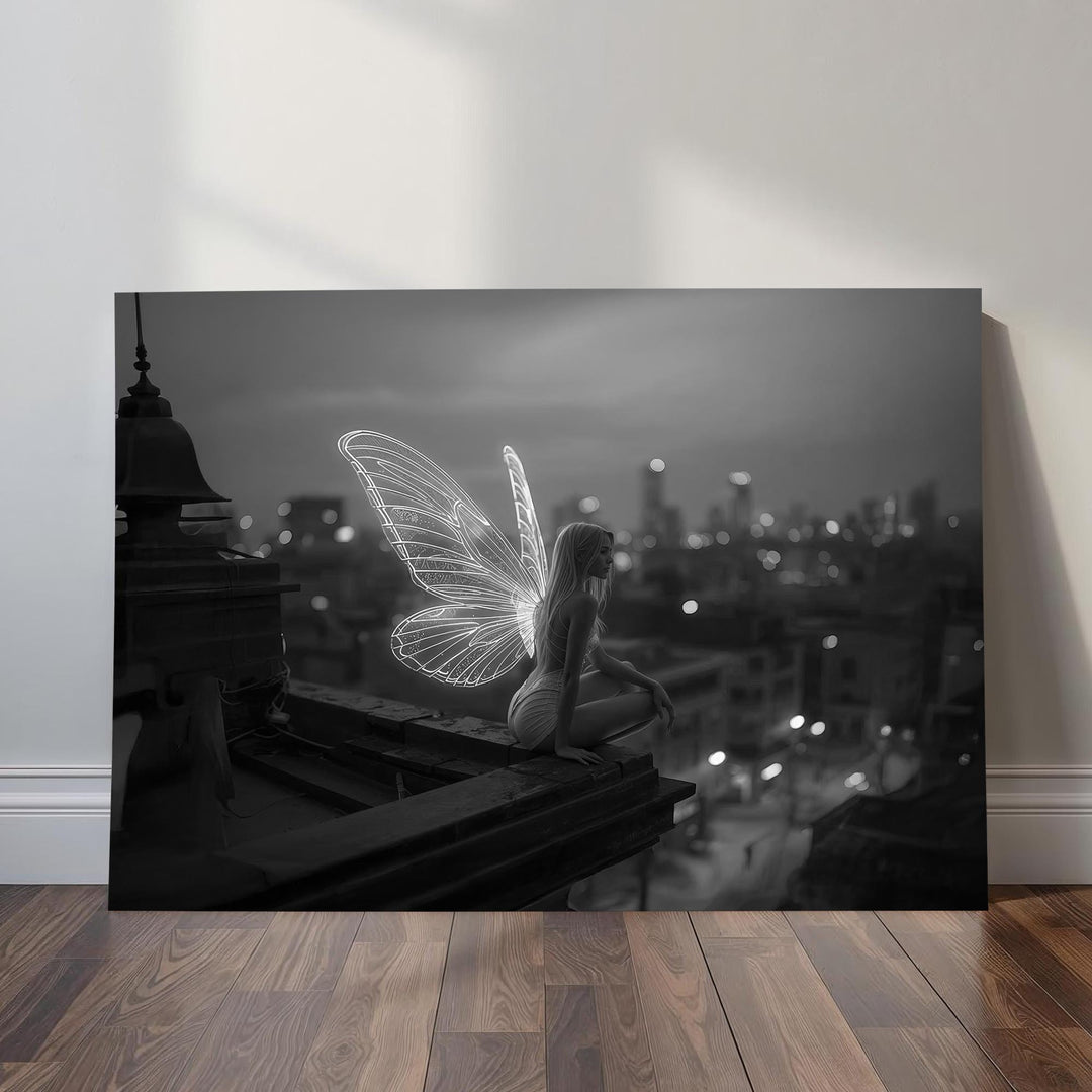 An ethereal fairy with bright wings crouches on the edge of a rooftop at night, overlooking a softly blurred black-and-white city skyline. The glowing wings illuminate the monochrome scene with a surreal, magical tone.